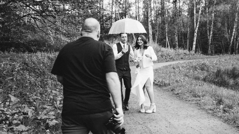 Peer photographing a couple under an umbrella
